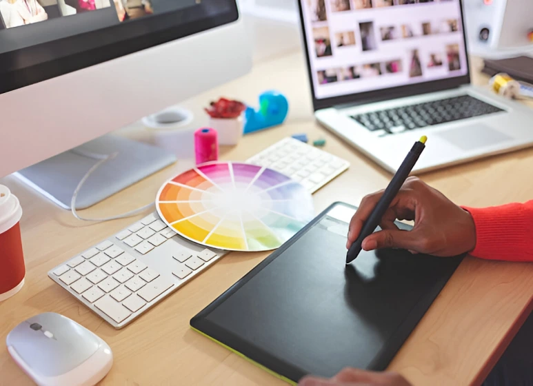 A digital workspace featuring a person using a graphic tablet and color swatches, illustrating the creative branding process at MindBees.